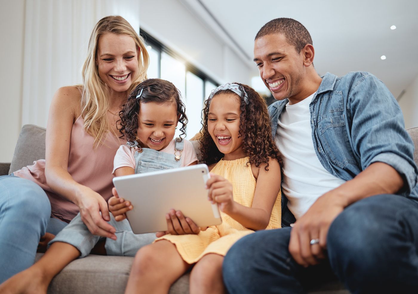 Interracial family laughing together on a sofa