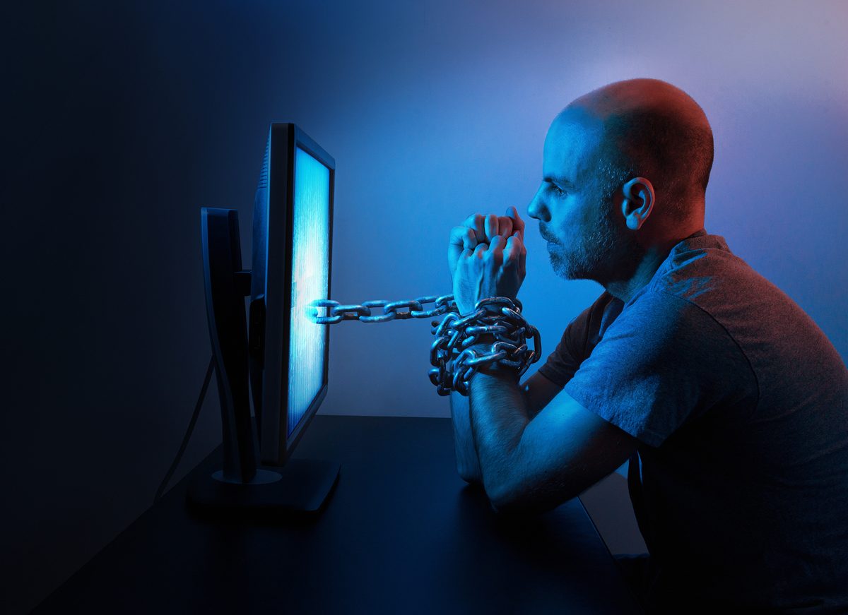 A person at a desk overwhelmed by work